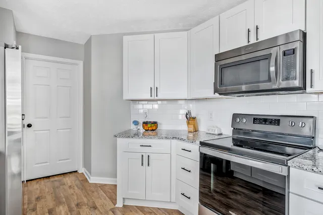 a kitchen with appliances a sink and cabinets