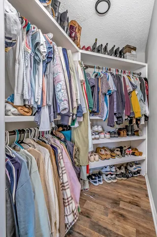 a view of walk in closet with clothes and shoes