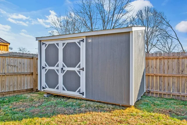 a backyard of a house with lots of green space and wooden fence