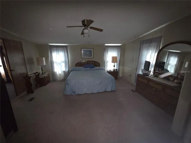 a spacious bedroom with a bed a couch and dresser