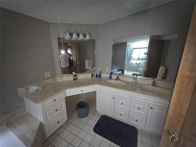 a bathroom with a granite countertop double sink and a mirror