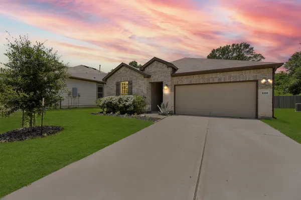 a front view of a house with a garden