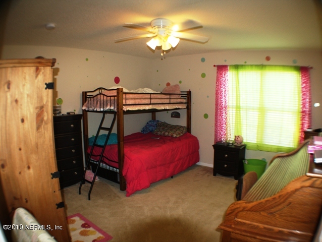 54178 Snyder Road Callahan, FL 32011 - Photo 8 of 14 a bedroom with a bed and a chandelier