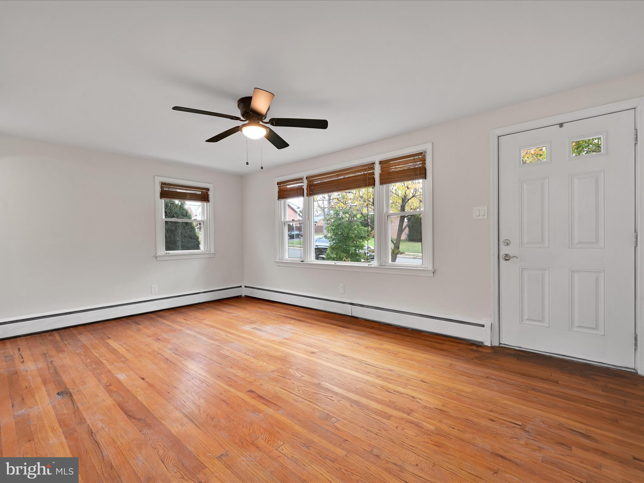 1609 Fayette Avenue Reading, PA 19607 - Photo 9 of 27 an empty room with wooden floor ceiling fan and windows