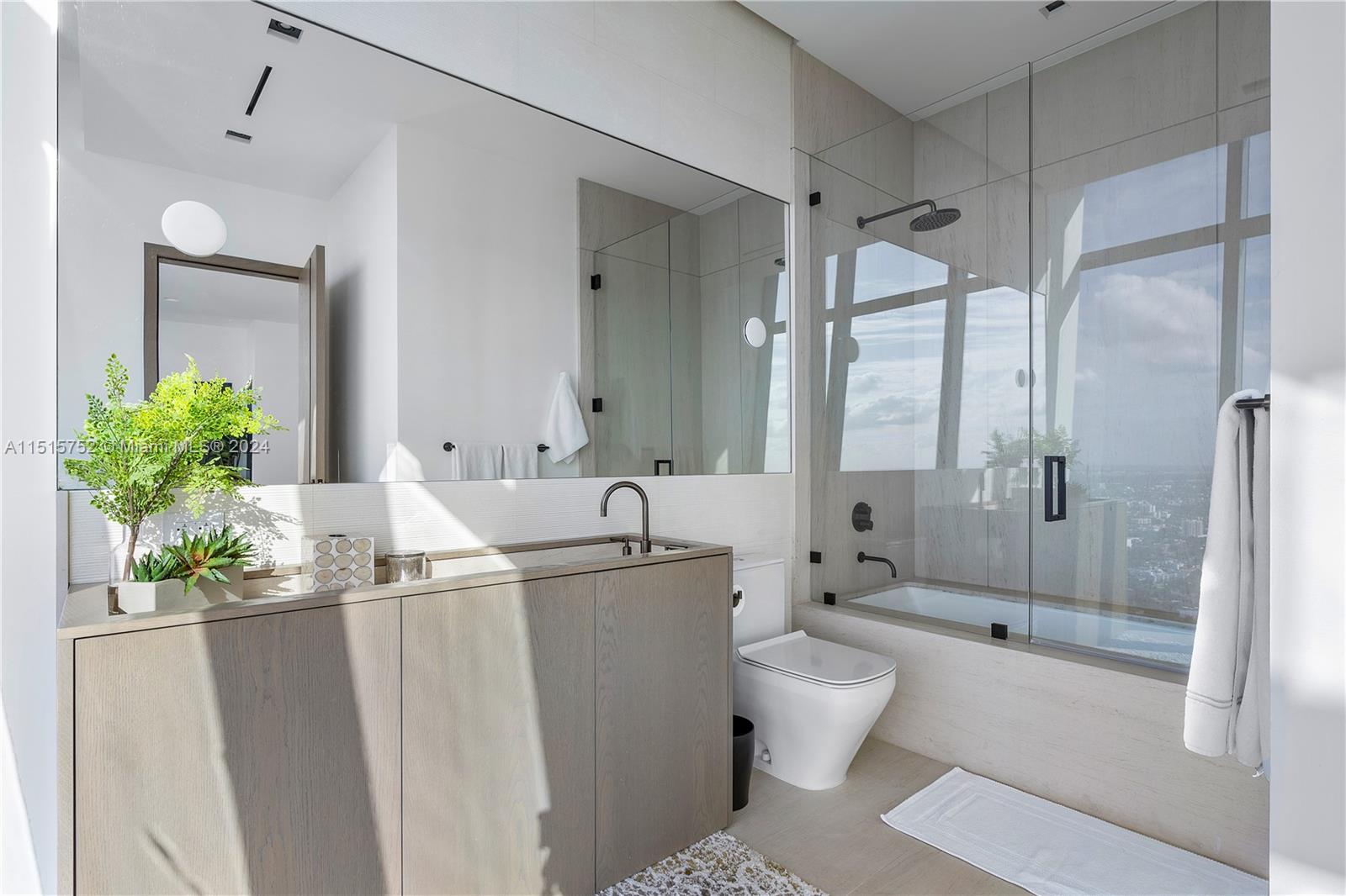 1451 Brickell Avenue, Unit PH56 Miami, FL 33131 - Photo 33 of 54 a bathroom with a granite countertop sink a toilet a mirror and shower