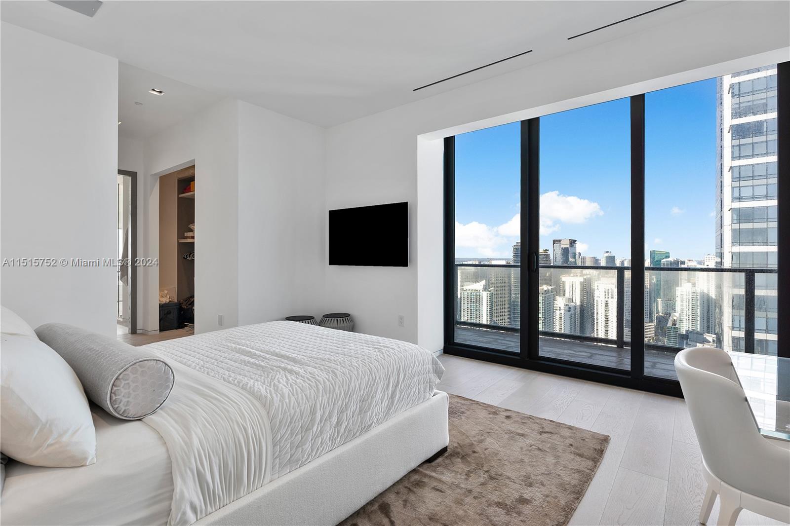 1451 Brickell Avenue, Unit PH56 Miami, FL 33131 - Photo 35 of 54 a bedroom with a large bed and a flat tv screen on the dresser