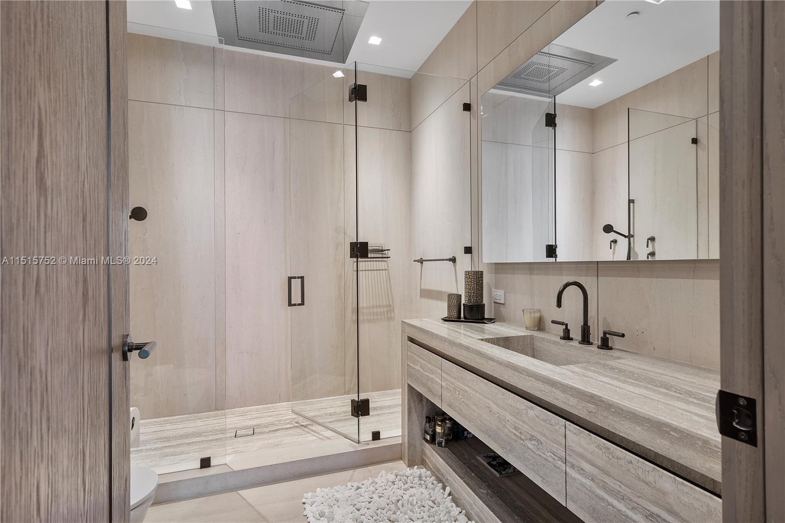 1451 Brickell Avenue, Unit PH56 Miami, FL 33131 - Photo 40 of 54 a bathroom with a sink and a mirror with bathtub