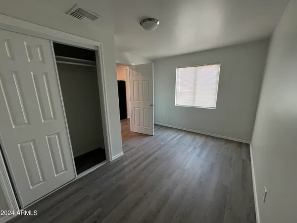 an empty room with wooden floor and a window