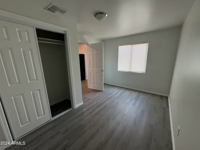 an empty room with wooden floor and a window