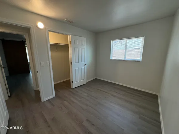 an empty room with wooden floor and closet