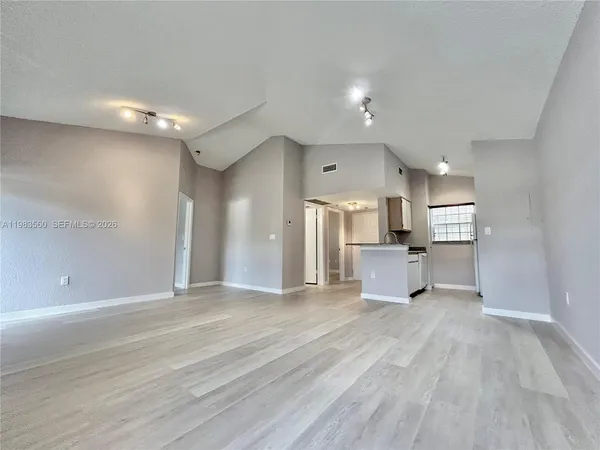 a view of a kitchen with a sink and a refrigerator