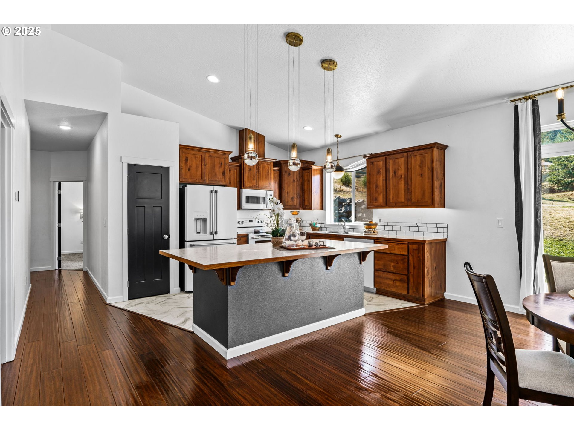 2187 East Madison Avenue Cottage Grove, OR 97424 - Photo 10 of 41 a kitchen with stainless steel appliances kitchen island granite countertop a stove a sink a refrigerator and a wooden cabinets
