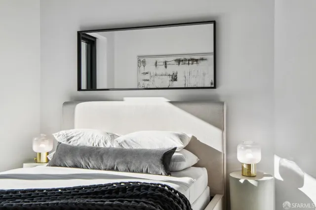 a bedroom with a bed and a painting on the wall