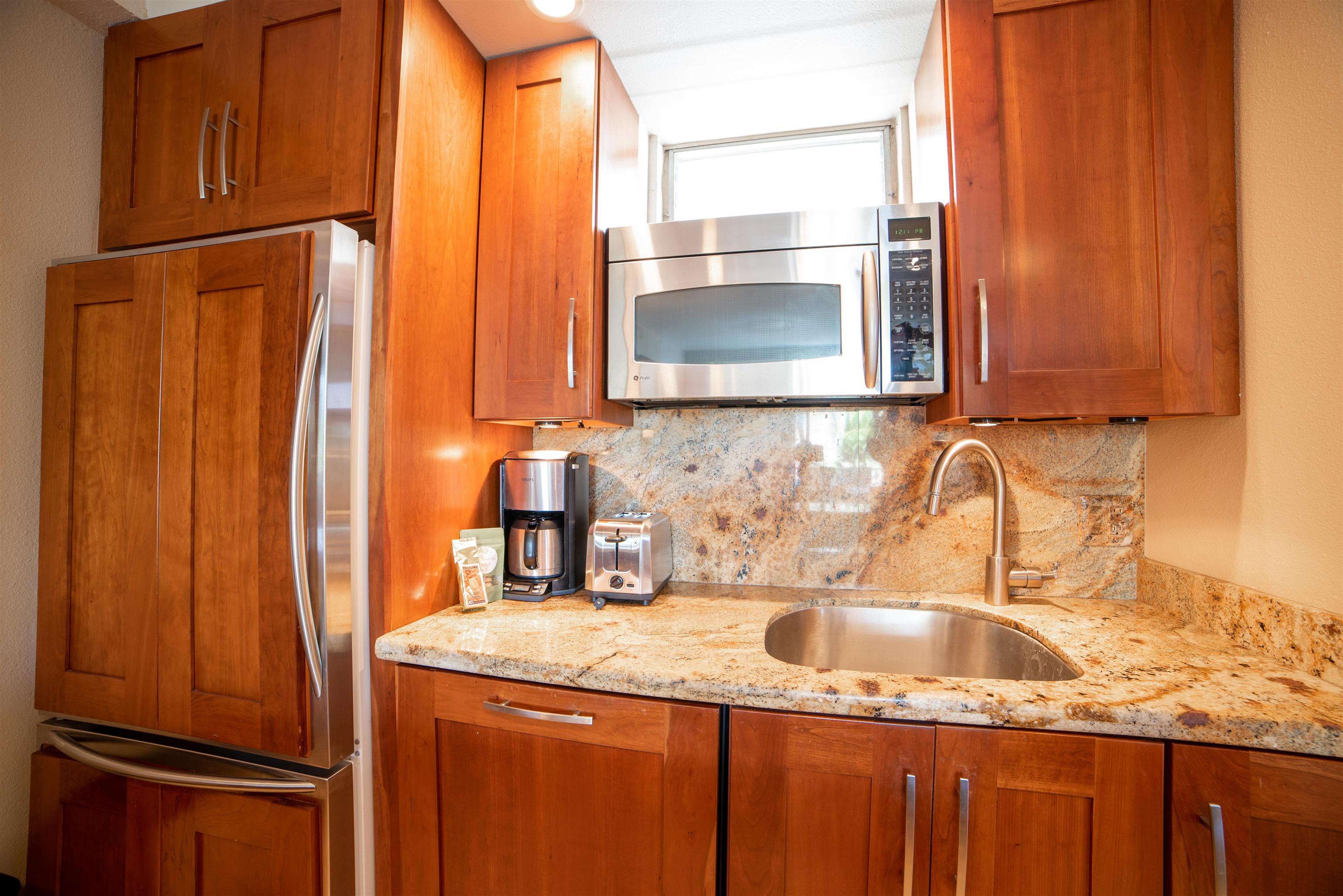 73 North Kihei Road, Unit 308 Kihei, HI 96753 - Photo 15 of 23 a kitchen with granite countertop a sink stainless steel appliances and cabinets