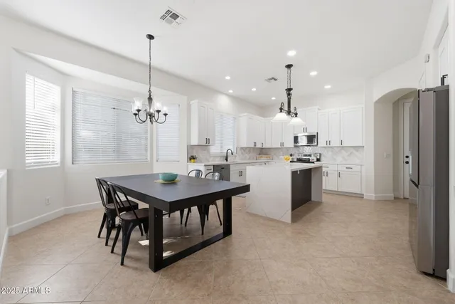 a large white kitchen with a sink and cabinets