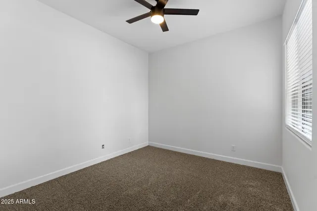 a view of a livingroom with a ceiling fan & entryway