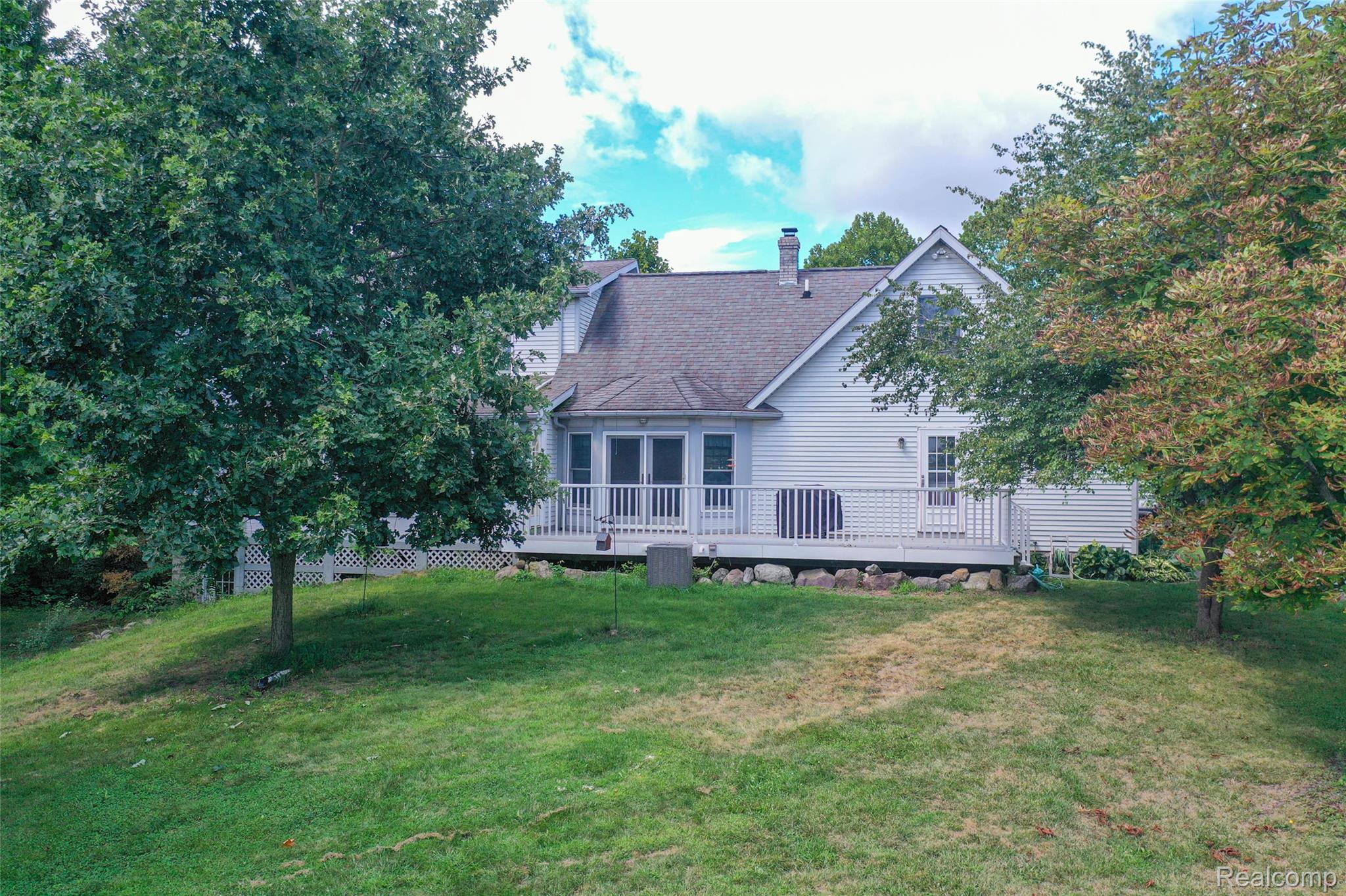 1591 Baldwin Road Lapeer, MI 48446 - Photo 34 of 46 Back of property featuring a yard, a chimney, a deck, and a shingled roof