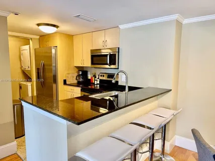 a kitchen with stainless steel appliances granite countertop a sink refrigerator and microwave