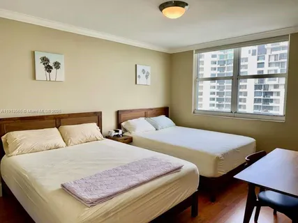 a bedroom with two beds and a window