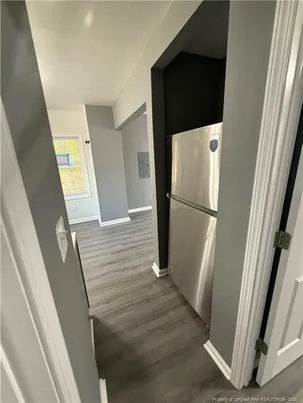 a view of a hallway with wooden floor and door