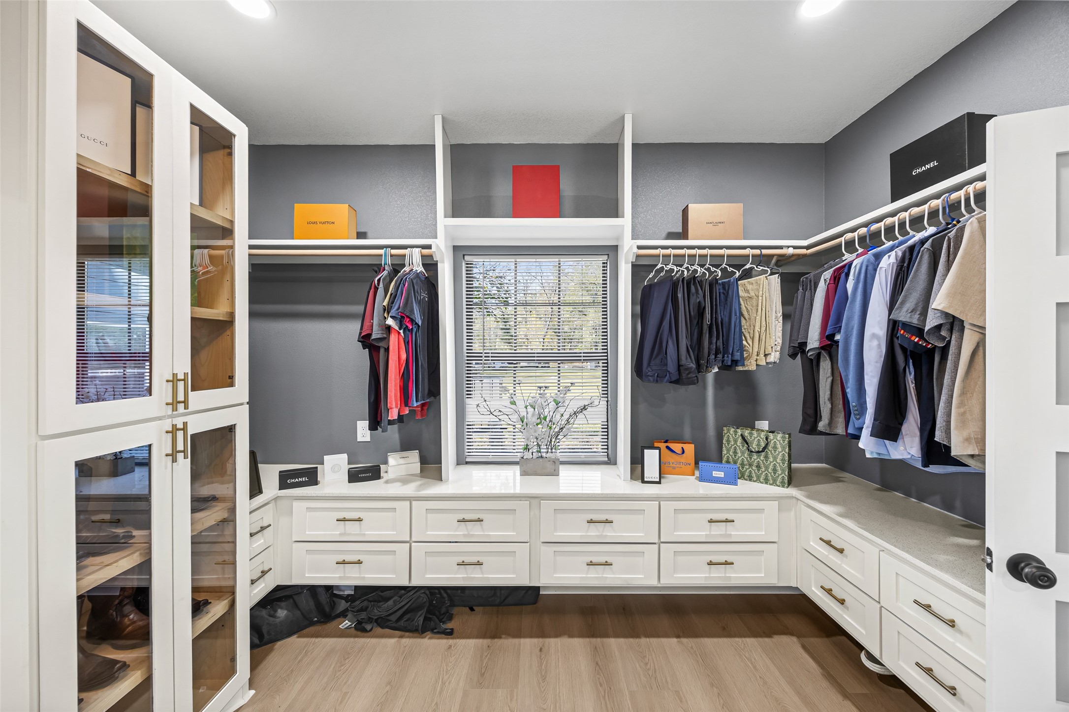 15080 Usher Lane Splendora, TX 77372 - Photo 28 of 44 This photo shows a spacious, well-organized walk-in closet featuring ample shelving and hanging space, sleek white cabinetry, and a window providing natural light.