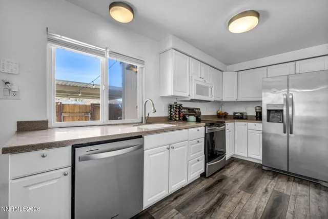 a kitchen with white cabinets and white appliances