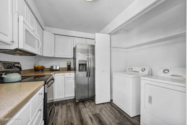 a kitchen with a white cabinets and wooden floor