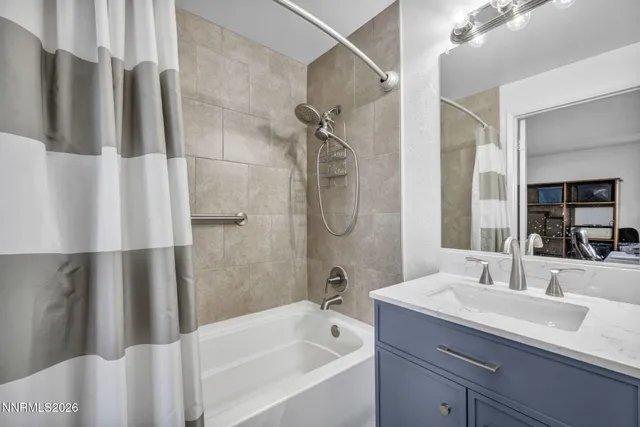 a bathroom with a granite countertop sink a mirror a shower and a bathtub