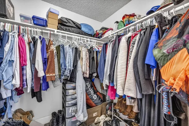 a view of walk in closet with clothes and shoes