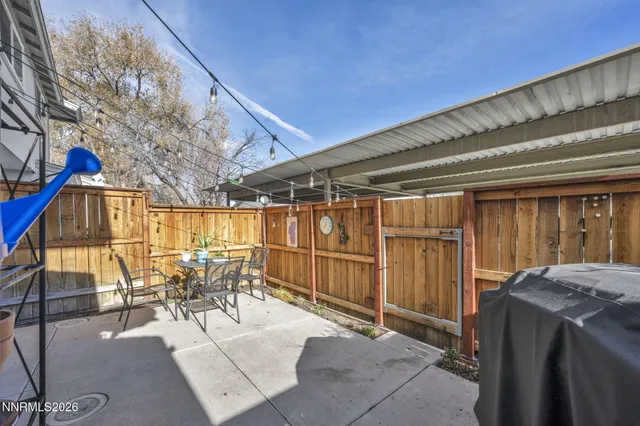 a view of a chairs and table in patio with wooden fence