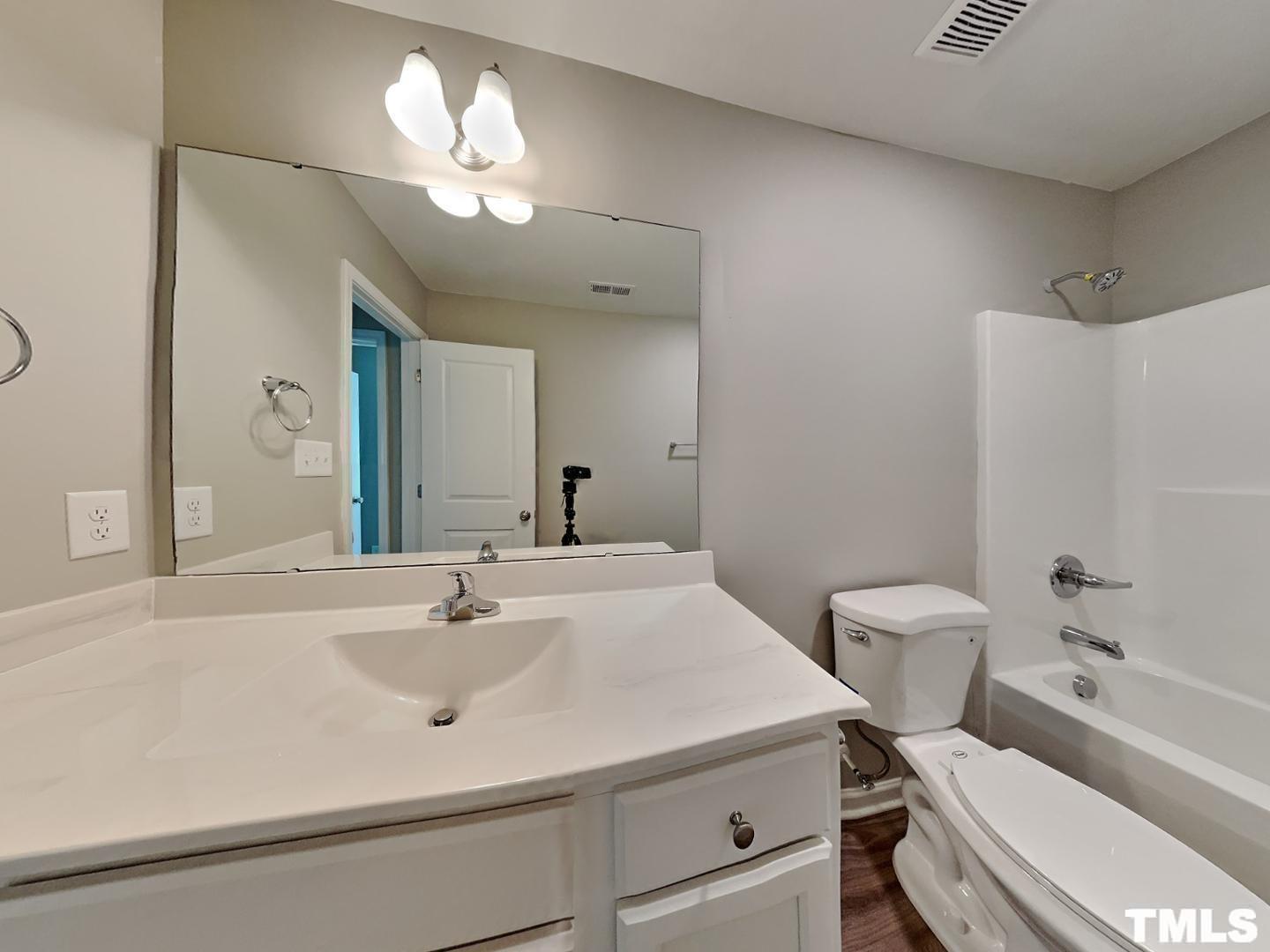 142 Beaver Tavern Drive Benson, NC 27504 - Photo 12 of 16 a bathroom with a sink a toilet and a mirror