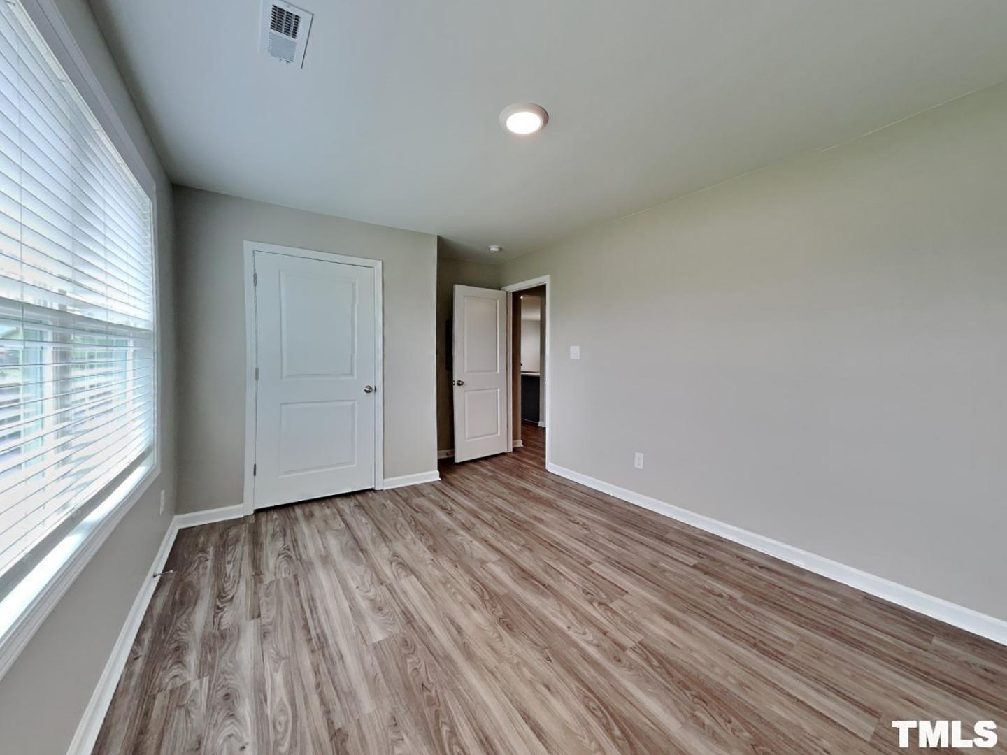 142 Beaver Tavern Drive Benson, NC 27504 - Photo 15 of 16 a view of an empty room with wooden floor and a window