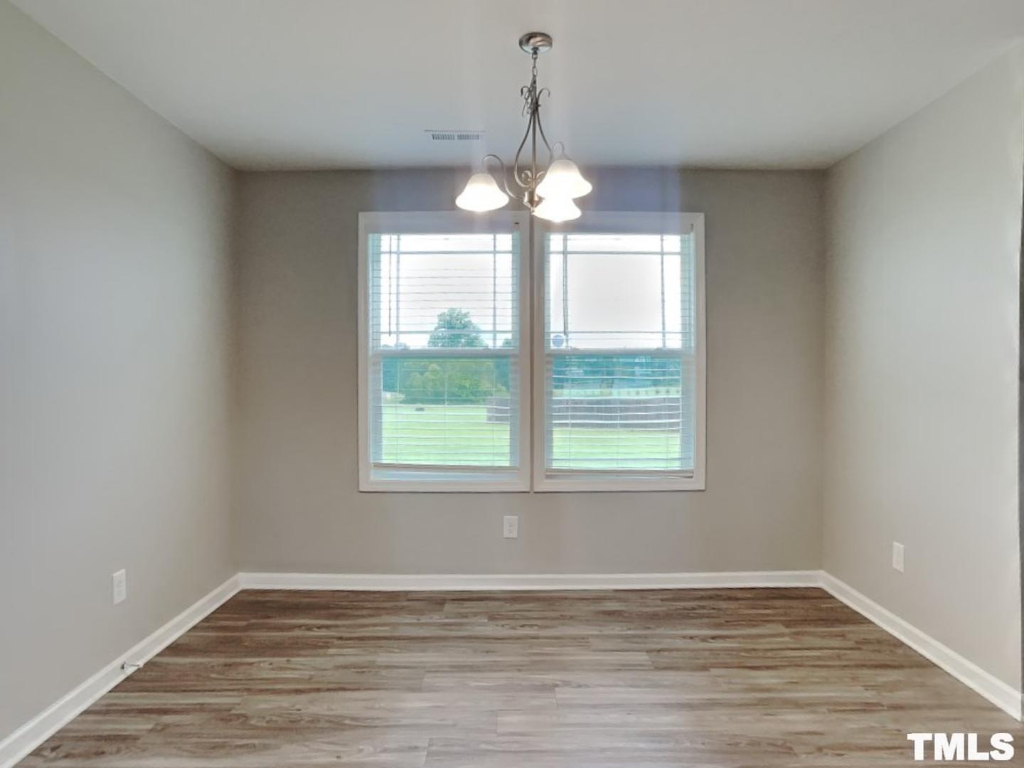 142 Beaver Tavern Drive Benson, NC 27504 - Photo 4 of 16 a view of an empty room with wooden floor and a window