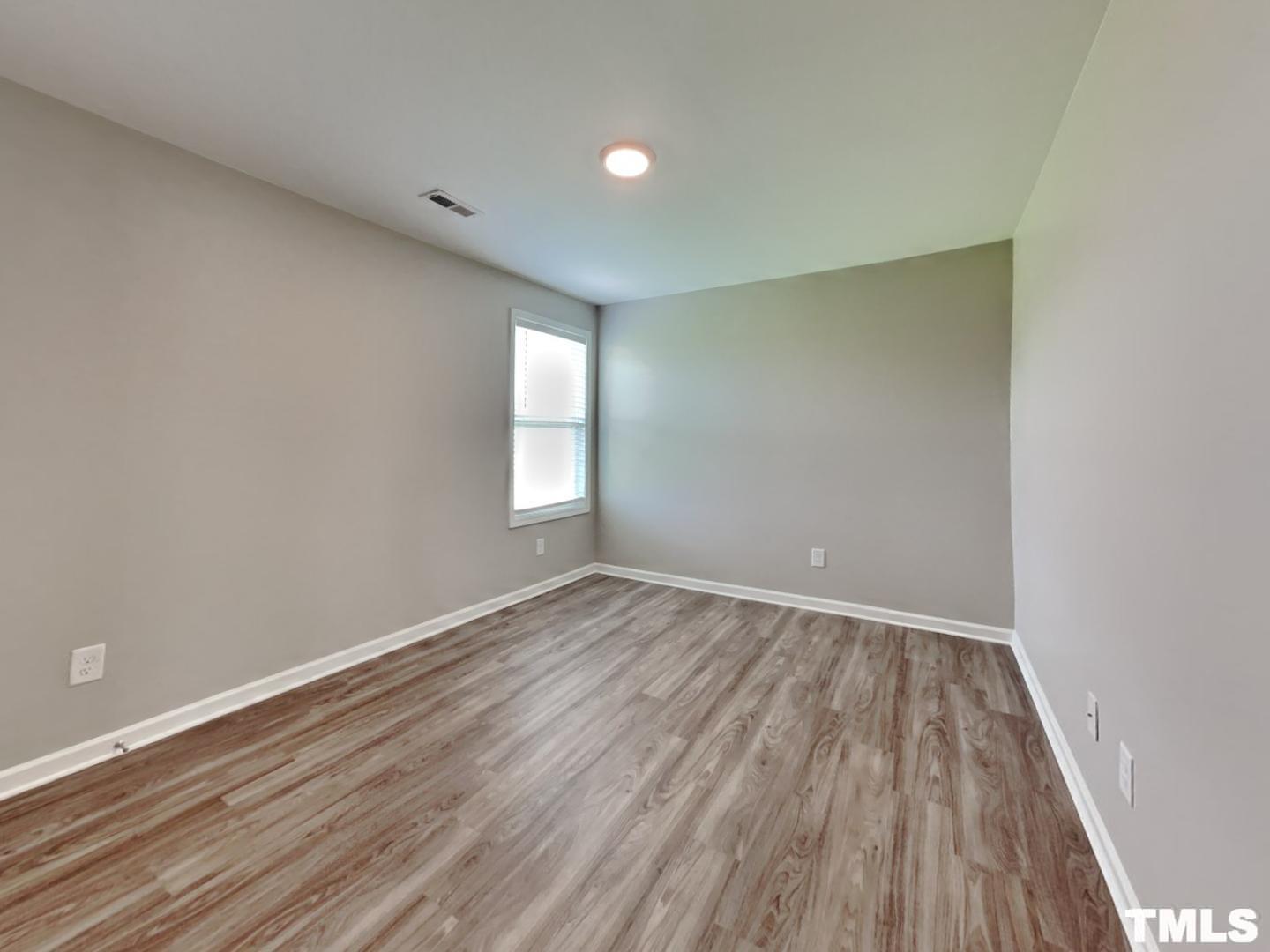 142 Beaver Tavern Drive Benson, NC 27504 - Photo 9 of 16 a view of an empty room with wooden floor and a window