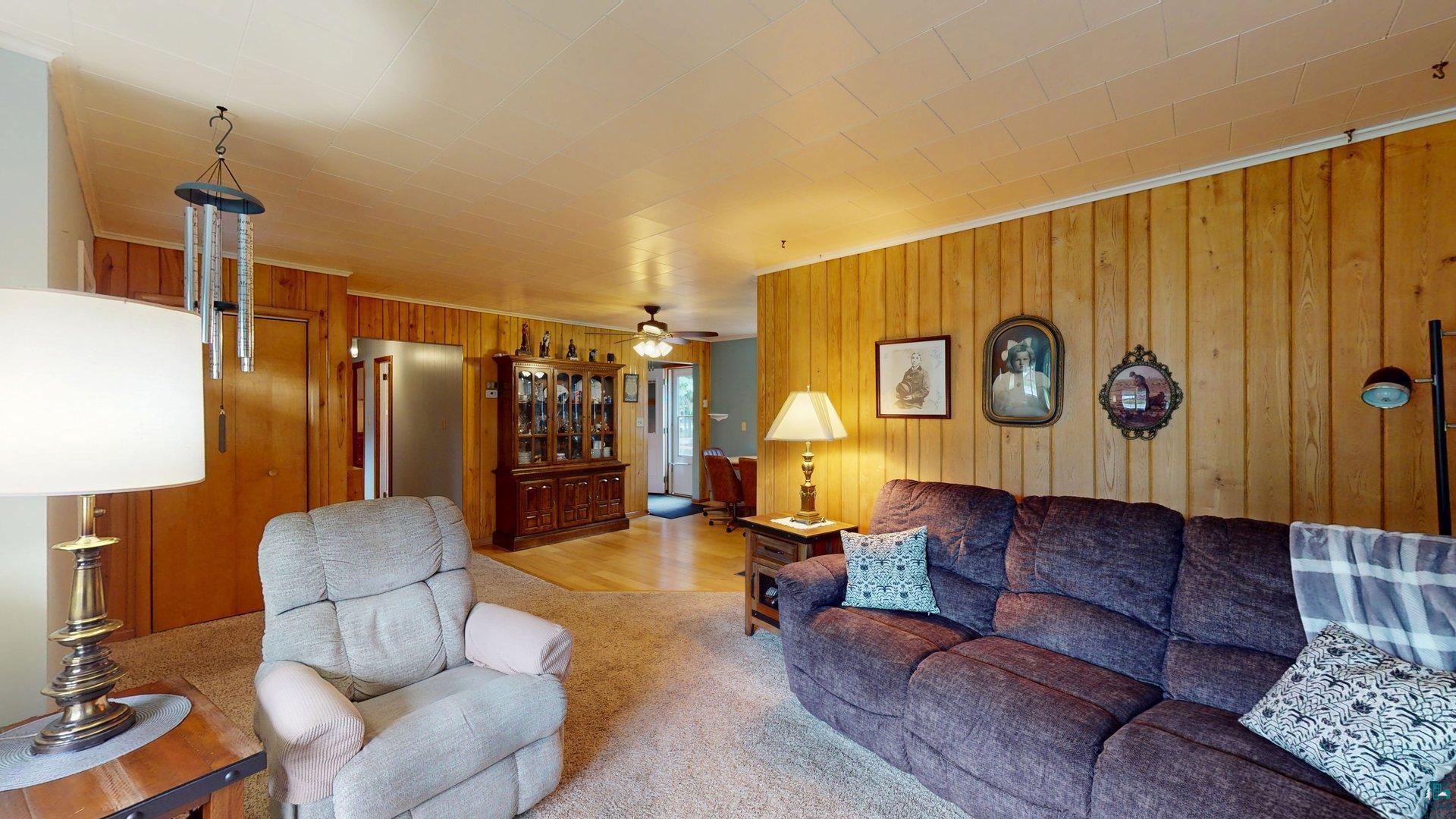10614 Moose Lake Road Orr, MN 55771 - Photo 18 of 44 Interior living space featuring wood paneling, carpet flooring, a light-colored ceiling, and a ceiling fan