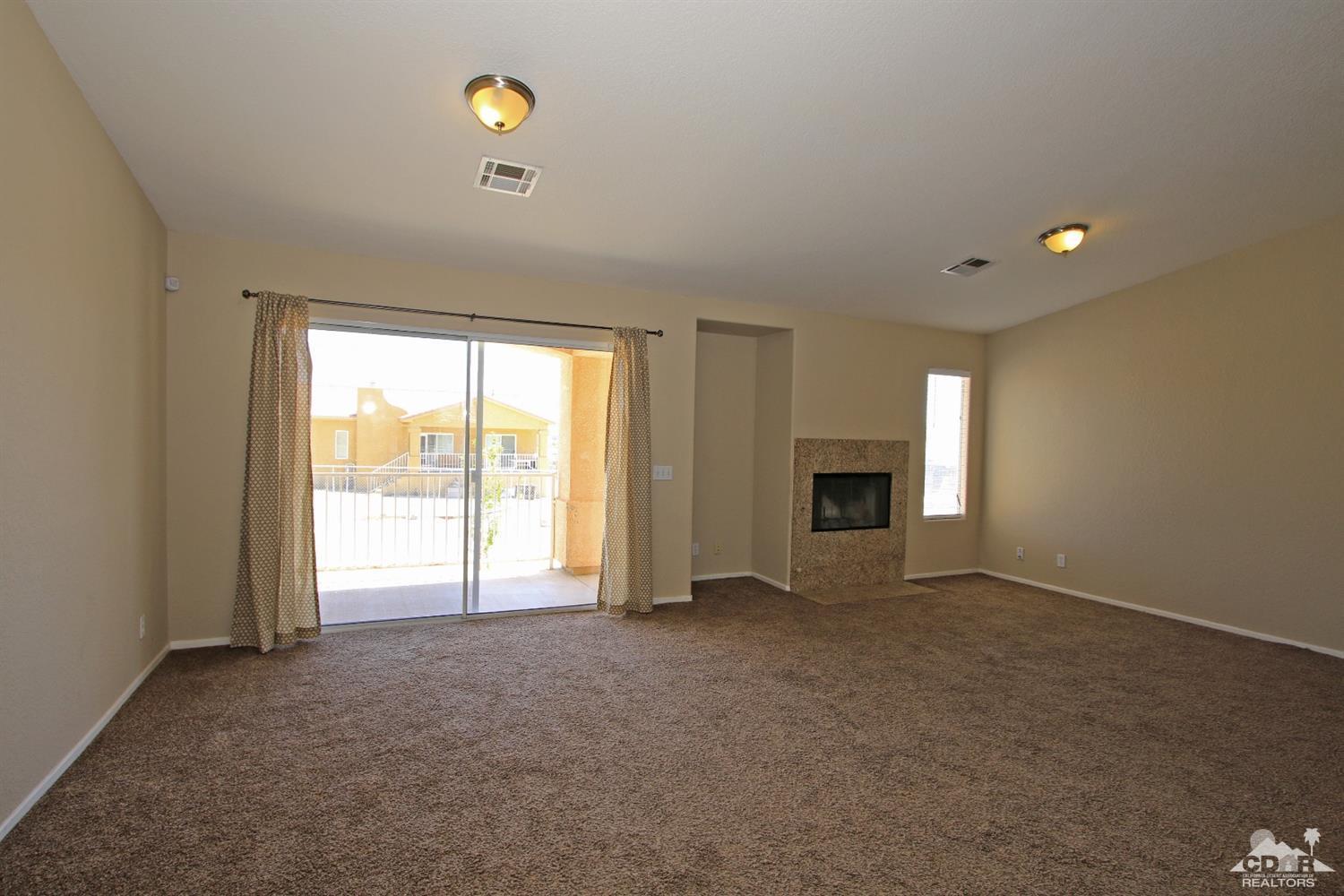 13810 United Road Desert Hot Springs, CA 92240 - Photo 11 of 41 a view of an empty room with a window and fireplace