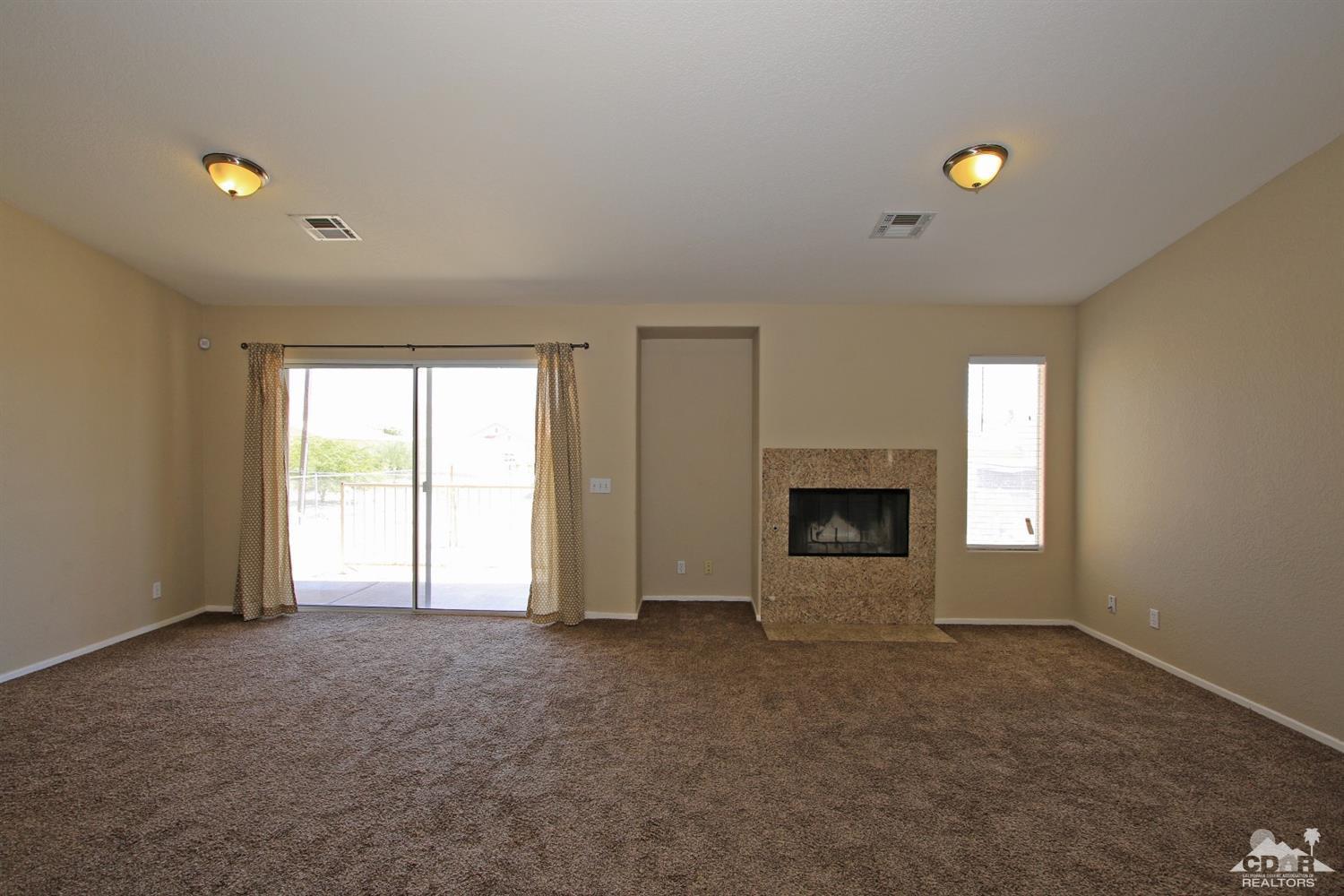 13810 United Road Desert Hot Springs, CA 92240 - Photo 12 of 41 a view of an empty room with a window and fireplace