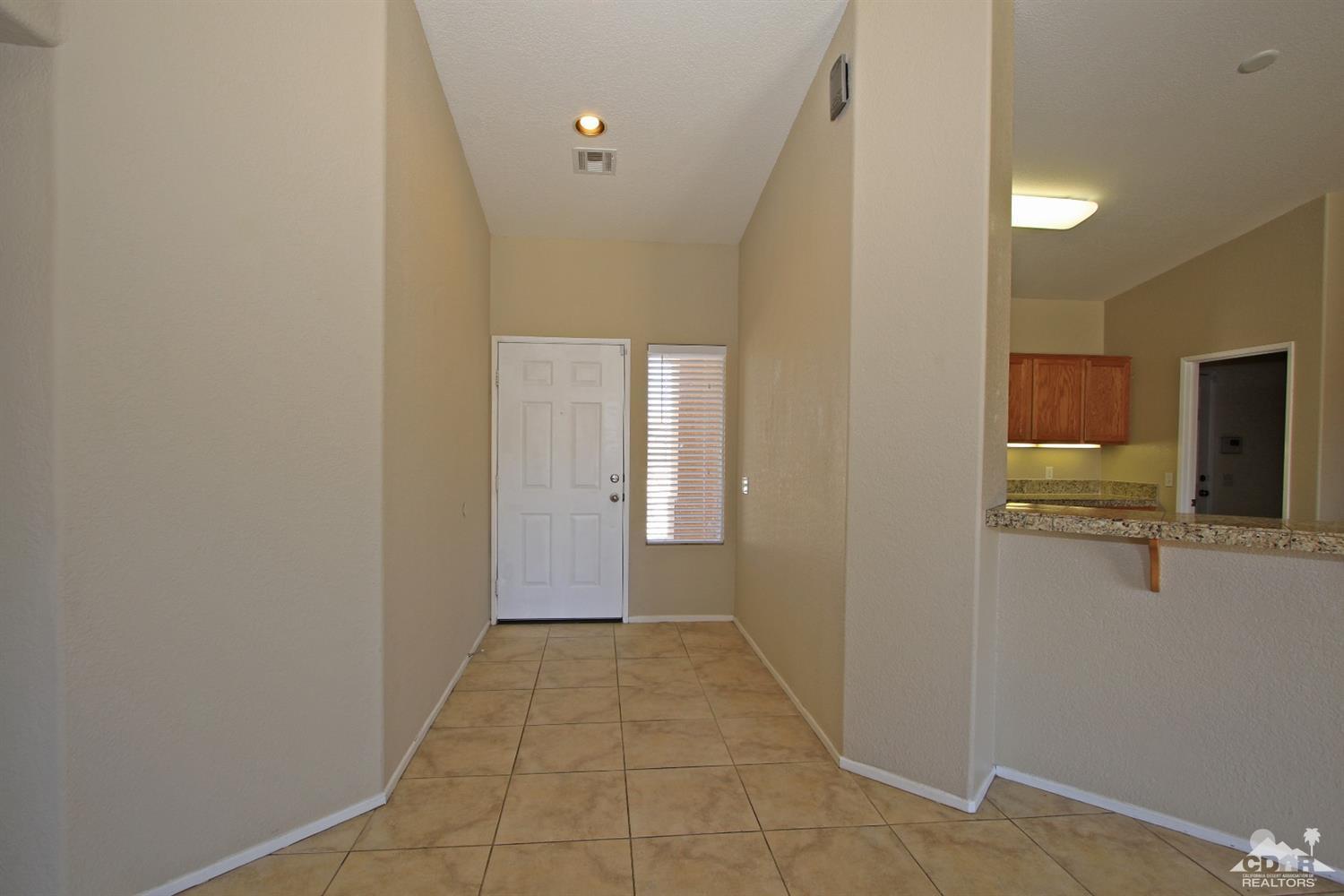 13810 United Road Desert Hot Springs, CA 92240 - Photo 14 of 41 a view of a hallway with wooden shelves