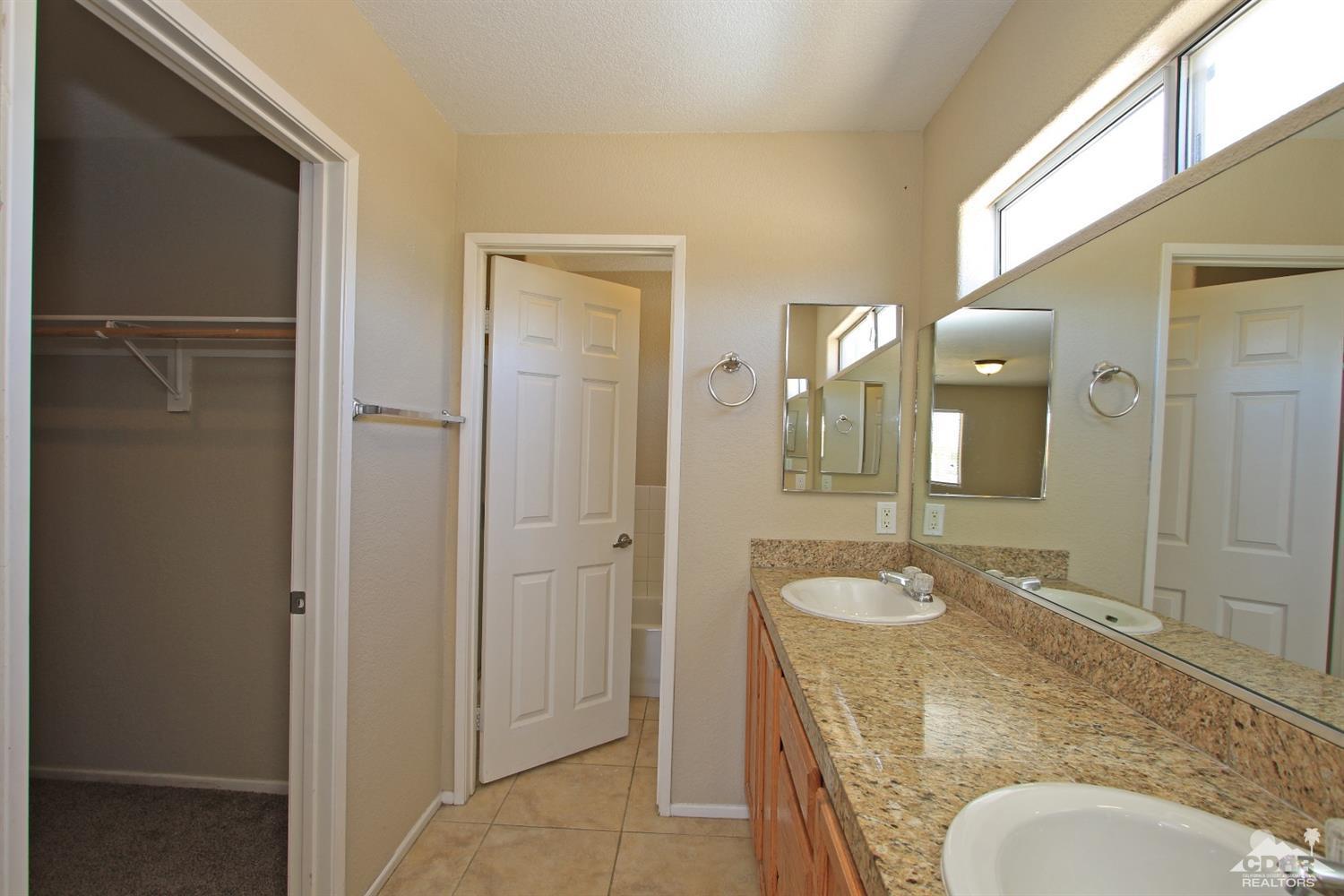 13810 United Road Desert Hot Springs, CA 92240 - Photo 19 of 41 a bathroom with a granite countertop sink and a mirror