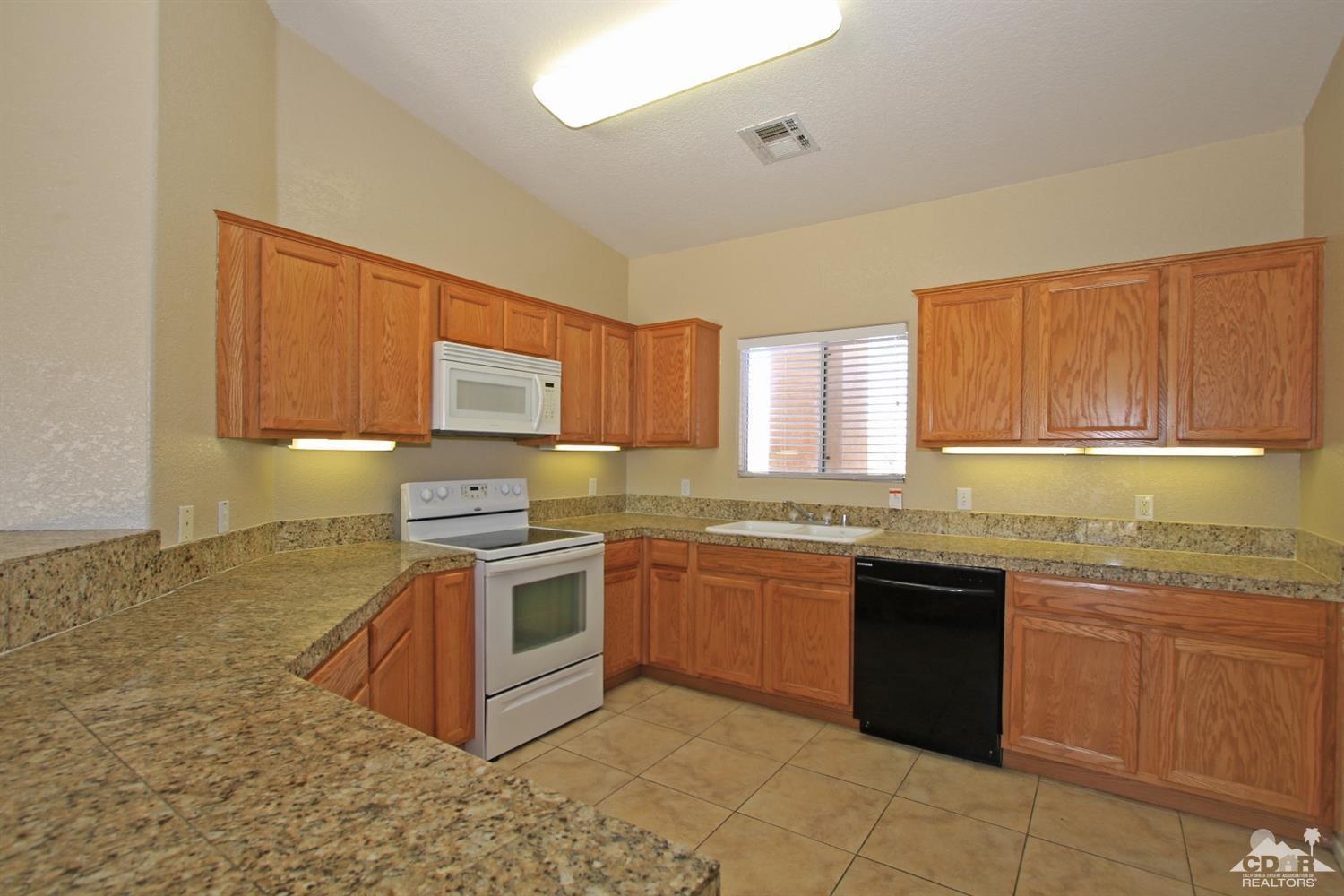 13810 United Road Desert Hot Springs, CA 92240 - Photo 7 of 41 a kitchen with stainless steel appliances granite countertop a stove sink and cabinets