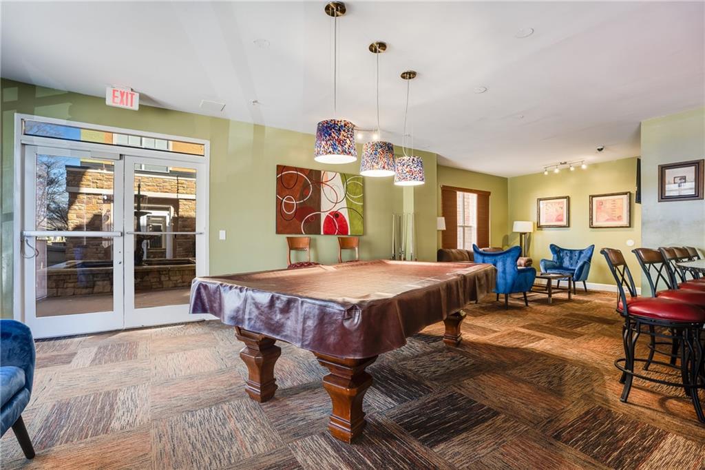 10 Perimeter Summit Boulevard, Unit 1404 Brookhaven, GA 30319 - Photo 29 of 39 a spacious bedroom with a bed a table and chair