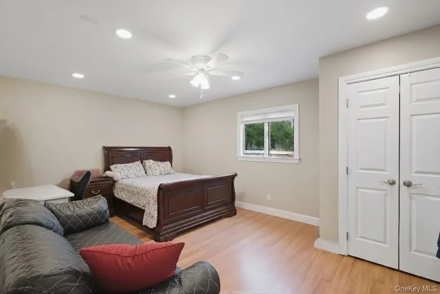 a spacious bedroom with a bed and wooden floor