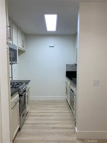 a kitchen with granite countertop white cabinets and stainless steel appliances