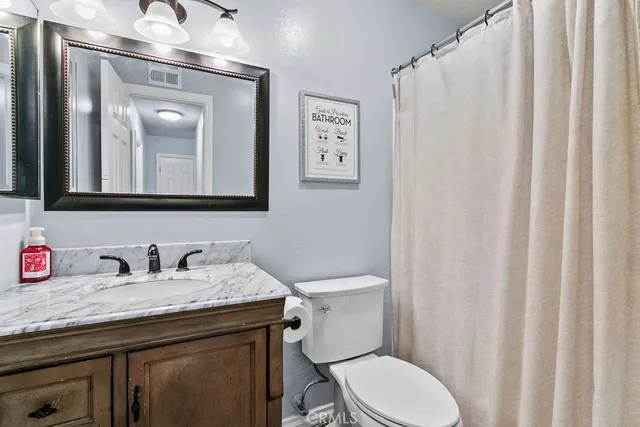 a bathroom with a toilet a sink and a mirror