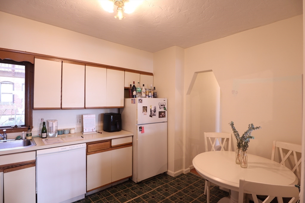 a kitchen with a white cabinets and chairs