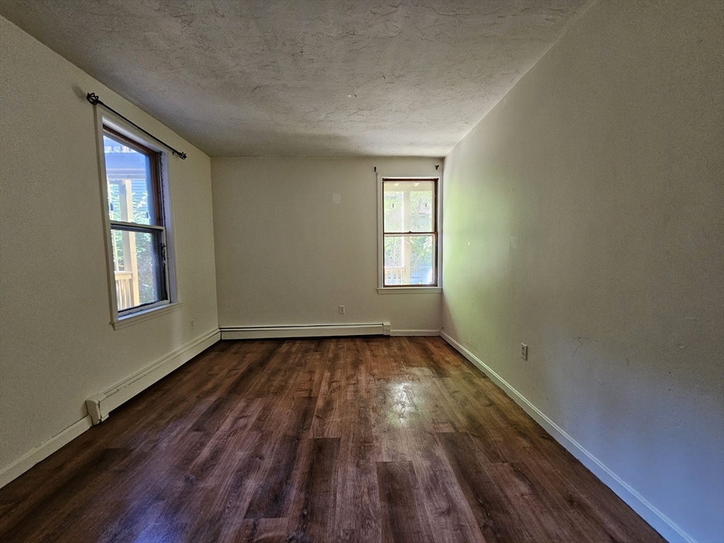 7 Saybrook Street, Unit 17 Boston, MA 02135 - Photo 6 of 30 a view of an empty room with wooden floor and window