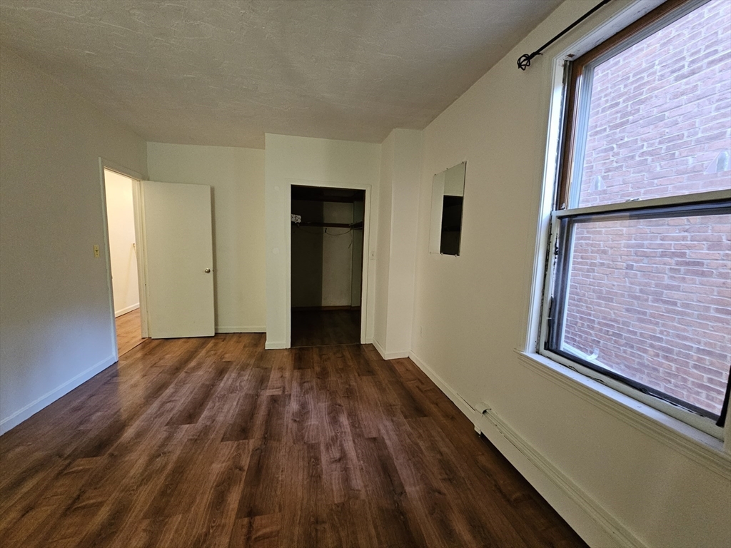7 Saybrook Street, Unit 17 Boston, MA 02135 - Photo 7 of 30 a view of an empty room with wooden floor and a window