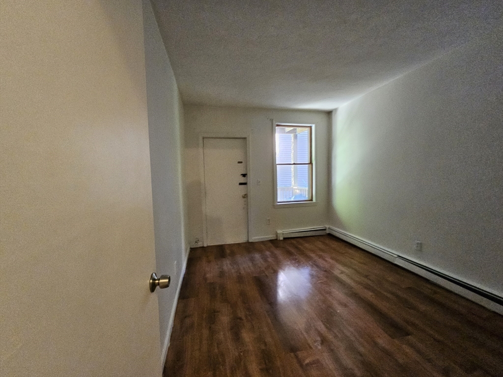 7 Saybrook Street, Unit 17 Boston, MA 02135 - Photo 10 of 30 an empty room with wooden floor and windows