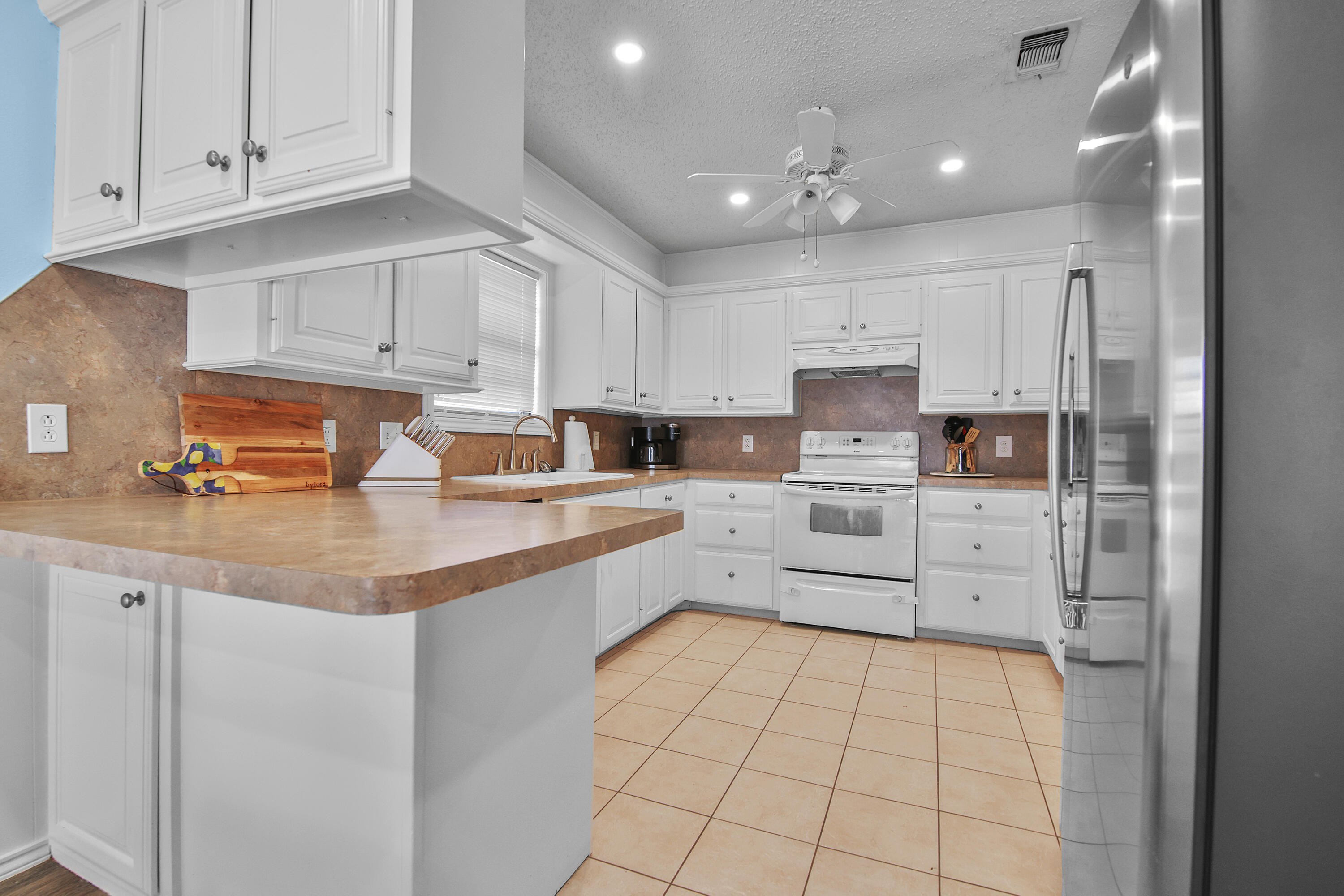 4805 73rd Street Lubbock, TX 79424 - Photo 9 of 26 a kitchen with stainless steel appliances a refrigerator sink and cabinets