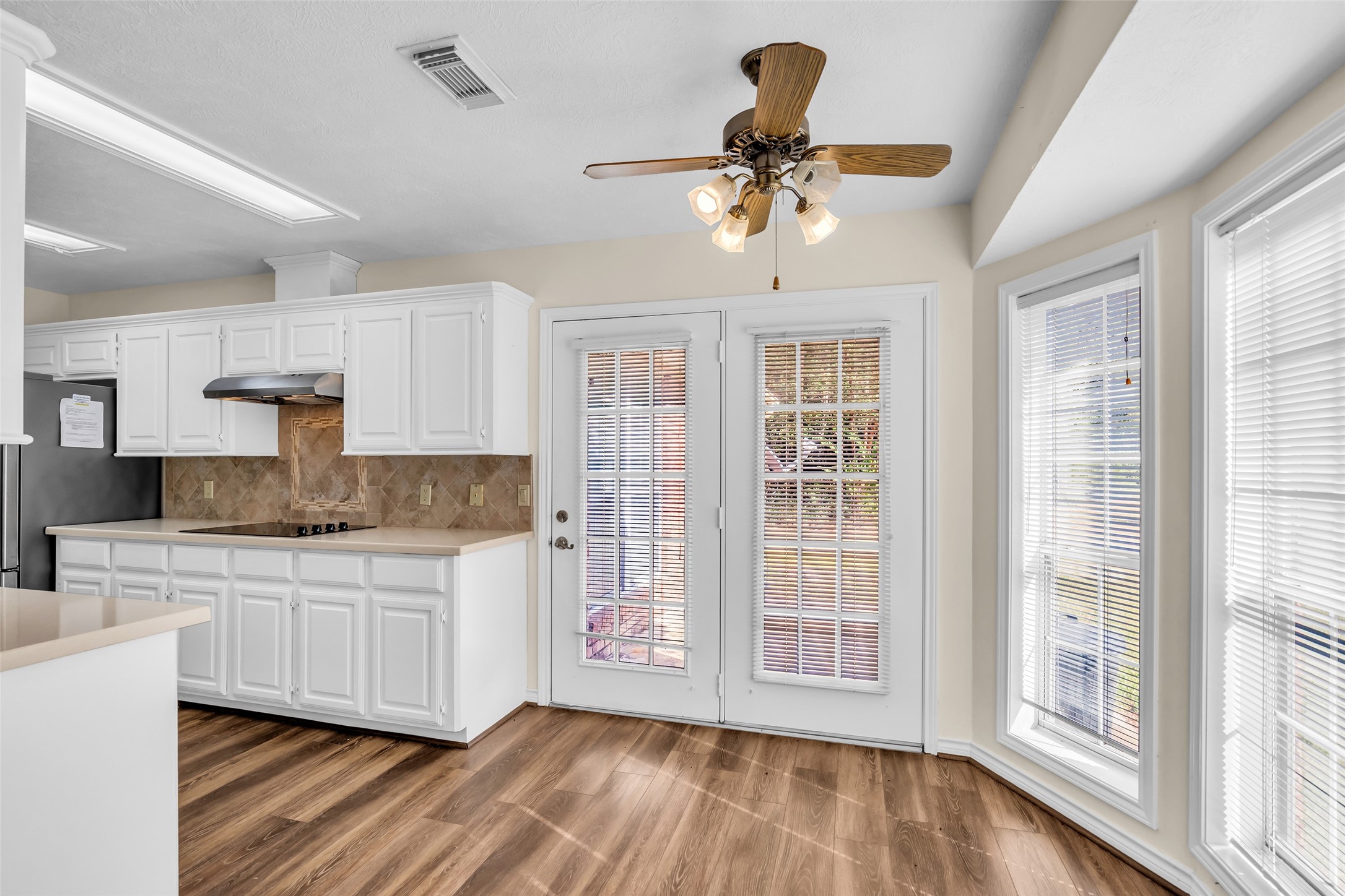 7 Lazy Spring Trinity, TX 75862 - Photo 8 of 25 Modern kitchen featuring crisp white cabinetry, a stylish tile backsplash with breakfast area.